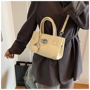 Detailed shot of cream leather bucket bag with silver twist lock and heart charm