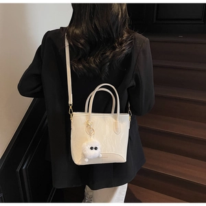 Détail du sac cabas blanc motif marbre avec bijou en peluche et bandoulière amovible