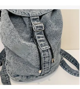 Détail de la texture en denim bleu clair avec boucle métallique et cordon de serrage