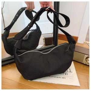 Detail of black crescent crossbody bag with wide shoulder strap and silver hardware