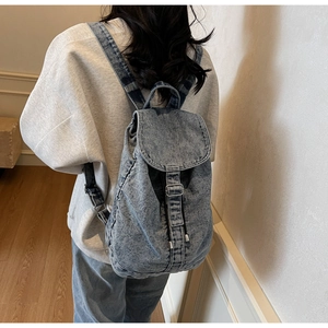 Détail d'un sac à dos en denim vintage avec fermeture à rabat et sangle à boucle
