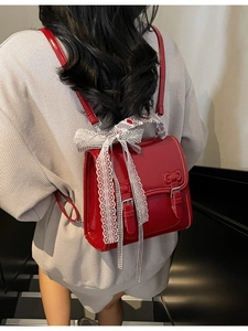 Glossy red backpack with lace details and bow, elegant women's fashion style