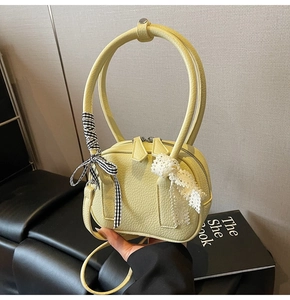Dettaglio della borsa a tracolla giallo limone con fiocchi decorativi in pizzo e tessuto a quadri