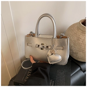 Close-up of silver crinkled leather bucket bag with twist-lock and heart charm