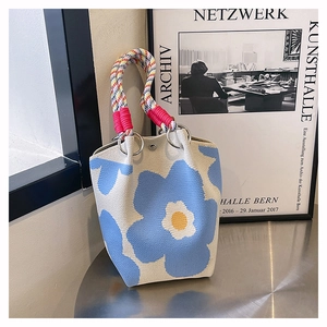 Gedetailleerde close-up van de gebreide bloemen emmer tas met kleurrijke handvatten