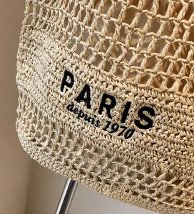 Detalle del bolso de paja hecho a mano con bordado PARIS negro y tejido calado de alta calidad