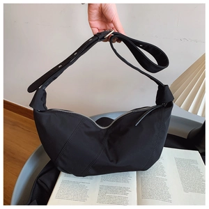 Detail of black nylon crescent bag with adjustable wide strap and silver hardware