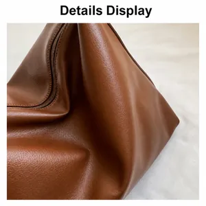Macro view of textured brown leather fabric and stitching detail on large tote bag