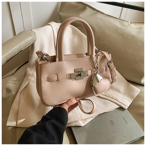 Detailed shot of light pink litchi grain leather bag with silver metal twist lock