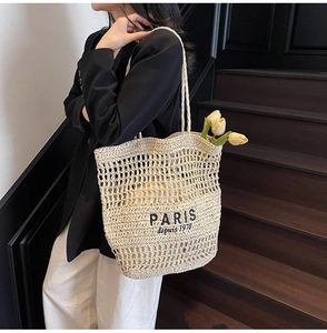 Détail du cabas en paille évidée tissé main avec broderie PARIS noire et doublure interne