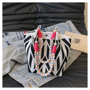 Detail van gebreide shopper met zwart-wit geometrische patronen en kleurrijk touwhandvat