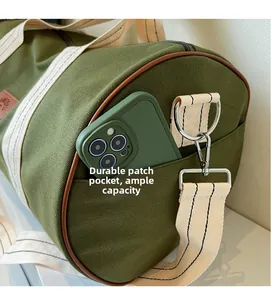 Detailed view of durable side pocket on army green canvas travel duffel bag with leather trim