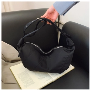 Detailed view of the black nylon moon bag showing its smooth texture and silver zipper