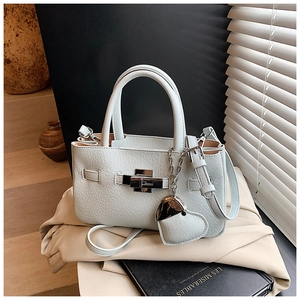 Detail of light blue lychee pattern leather bucket bag with metal lock and heart charm
