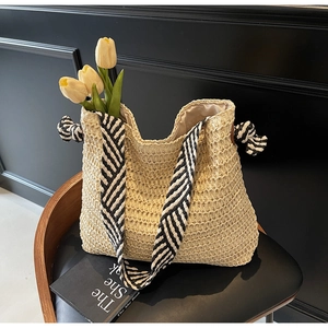 Détail du sac cabas tissé avec bandoulière rayée noir et blanc et des tulipes