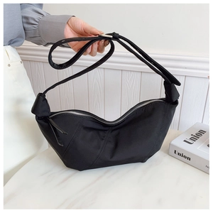 Detail of black nylon crescent bag with stylish pleated design and silver zipper closure