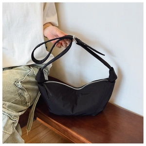 Detail of black pleated nylon hobo bag featuring quilted stitching and adjustable strap