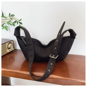 Detail of adjustable strap with silver metal eyelets on a black hobo bag for women