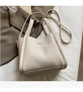 Détail d'un sac seau en cuir grainé crème avec boucle en métal et bandoulière