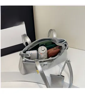 Top view of spacious interior of silver shoulder bag with wallet and phone storage