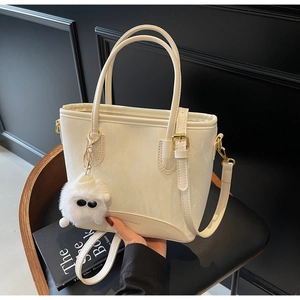 Détail du sac à main blanc crème avec quincaillerie dorée et charm pelucheux mignon