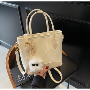 Détail du sac à main en cuir PU à motif marbre blanc avec breloque peluche sur fond noir