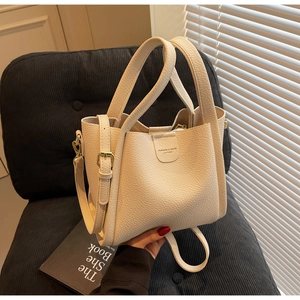 Détail du sac à main en cuir grainé avec finitions métalliques dorées élégantes