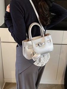 Silver lychee pattern bucket bag with heart pendant shown from a side-view by model