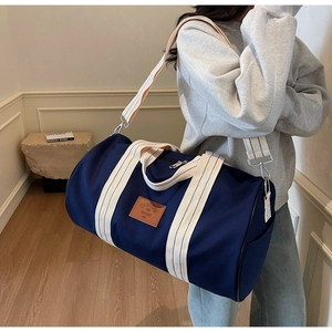 Close-up of durable navy canvas texture with leather brand patch and striped handles