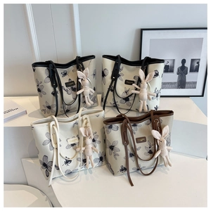 Détail du sac cabas en toile avec motifs floraux et pendentif lapin en peluche amovible