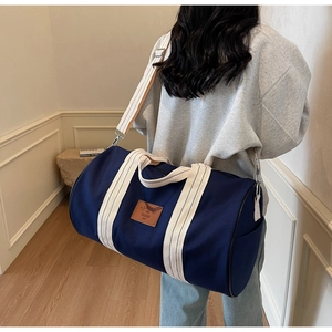 Detail of dark blue travel duffel bag with durable canvas texture and sturdy beige handles