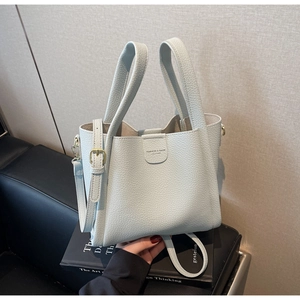 Détail du sac seau bleu clair avec cuir à grain lychee et garniture en métal doré