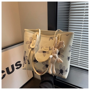 Détail du sac cabas en toile avec motif fleurs et abeilles et breloque lapin