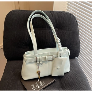 Detail of light blue shoulder bag with coin purse on black corduroy chair