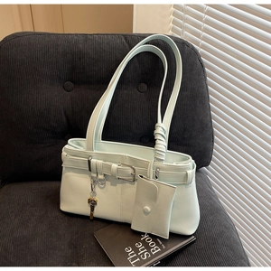 Detail of mint green tote bag with matching coin purse and golden key charm on chair