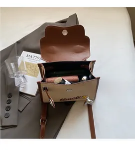 Interior detail of a brown leather and beige woven crossbody bag showing ample storage space