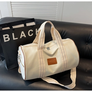 Detail of canvas duffel bag with leather trim on a sofa for outdoor travel and storage