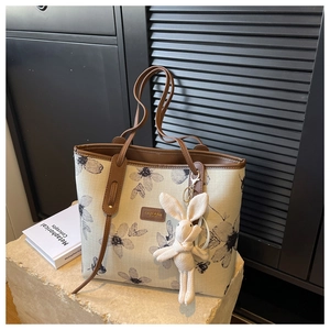 Détails du sac cabas en toile à fleurs avec anses en cuir et breloque lapin