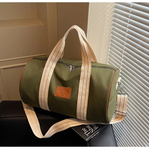 Close-up of canvas travel bag with leather logo patch and durable woven handles