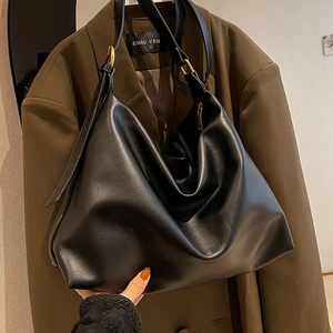 Minimalist large black leather hobo bag with gold hardware for daily commuting