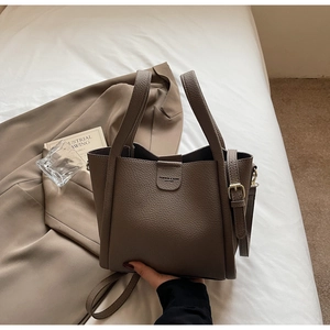 Détail du cuir grainé marron foncé et des coutures précises de ce sac fourre-tout