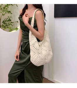 Close-up of bohemian ivory crochet shoulder bag with intricate floral cut-out patterns