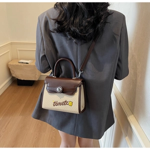 Detail of vintage brown leather and woven fabric handbag with a metal twist lock