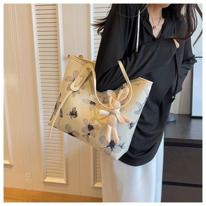Détail d'un sac cabas en toile avec motif floral noir et pendentif lapin mignon