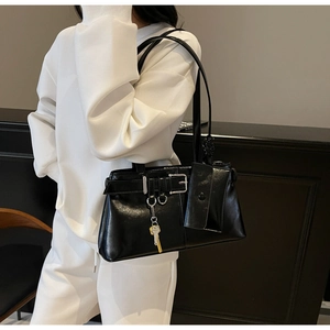 Detail of black faux leather tote with silver buckle and detachable mini pouch accessory