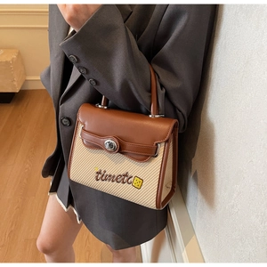 Detail of retro leather stitching and metal twist lock on women's crossbody bag