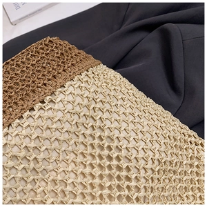 Detailed macro view of woven straw bag featuring contrast patterns and natural textures