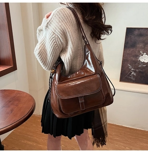 Détail du sac à bandoulière en cuir ciré marron foncé avec coutures contrastées