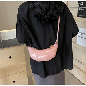 Detailed back view of a pink croissant shoulder bag with pleated shiny finish and zipper