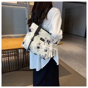 Vue détaillée arrière d'un sac cabas en toile blanc avec fleurs noires et breloque lapin